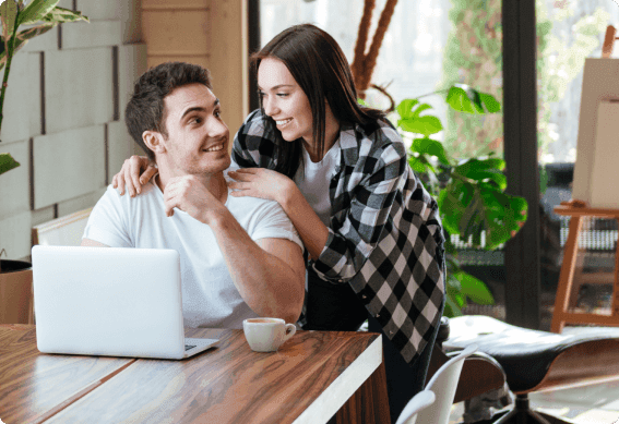 a man and a woman looking at a laptop