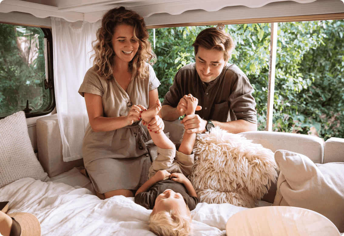 Parents laughing and playing with their child in an RV