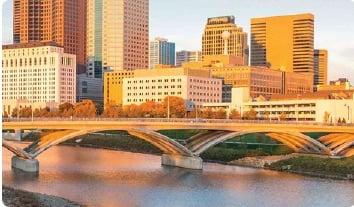 a bridge over a river with buildings in the background