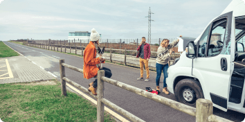 people standing outside a broken down vehicle