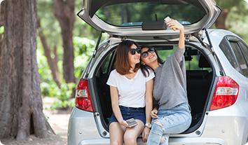 a man and woman sitting in the trunk of a car