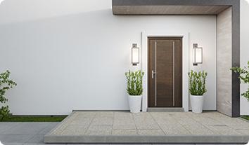 a white building with a door and potted plants