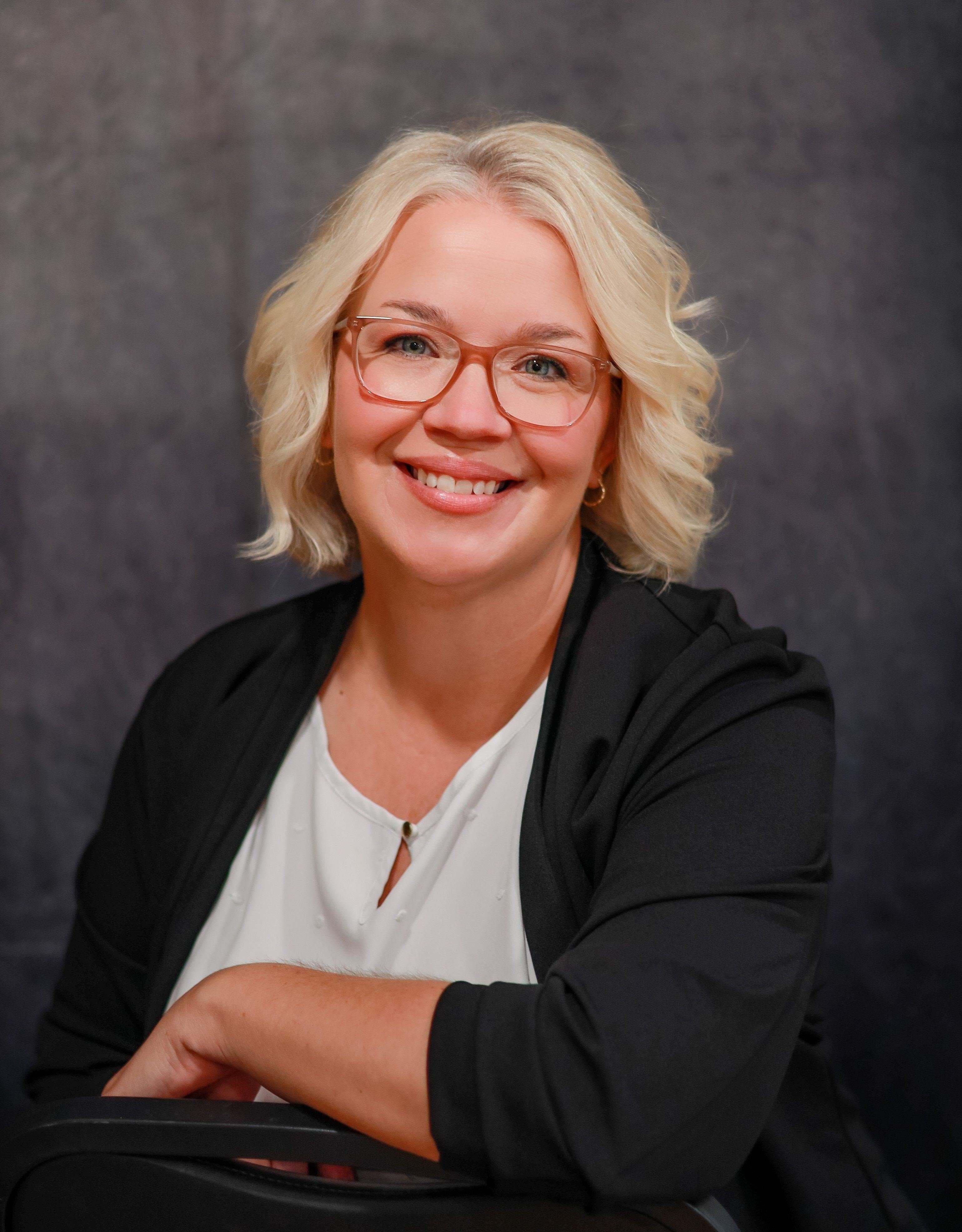 a woman with glasses smiling