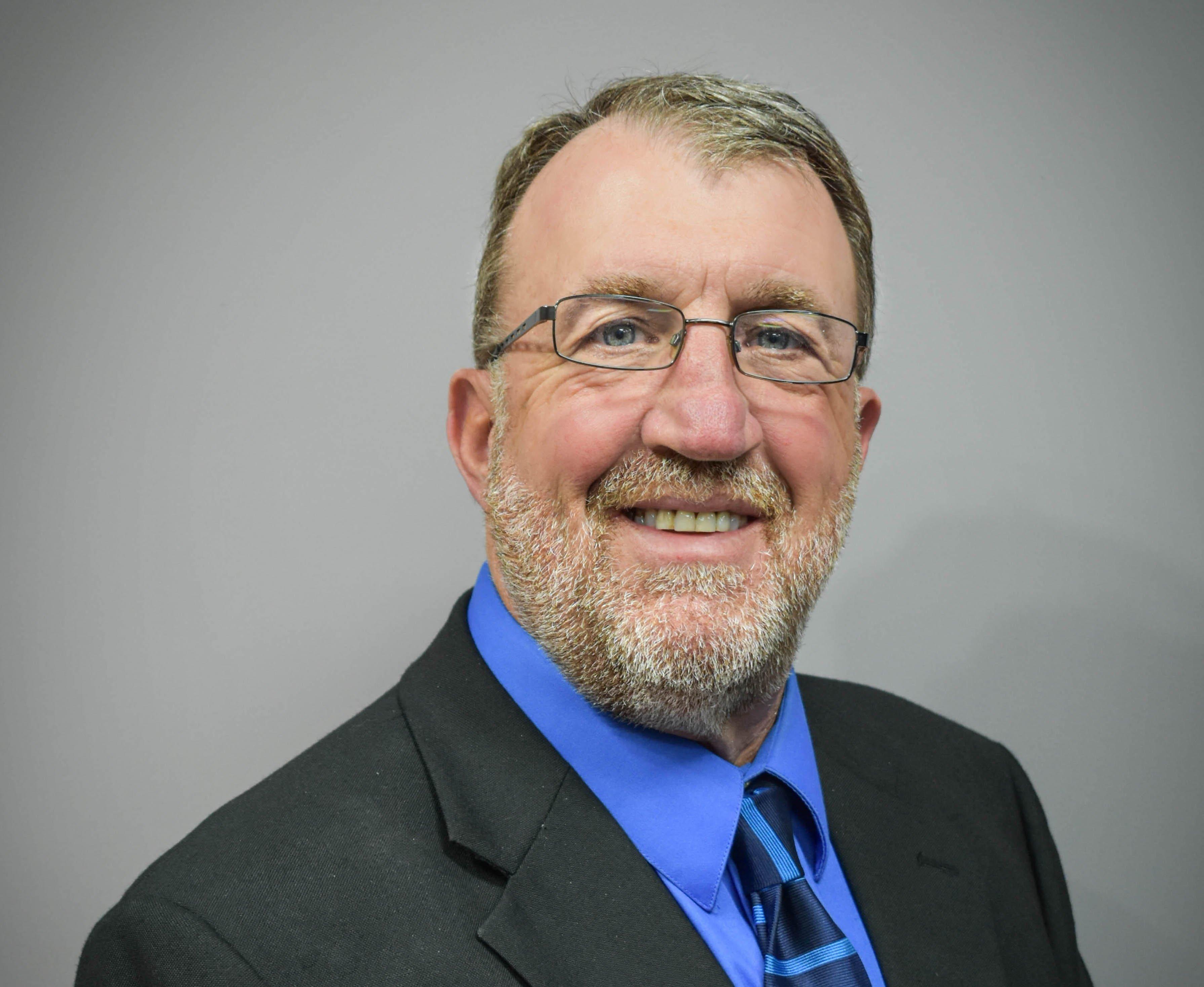 a man wearing glasses and a suit