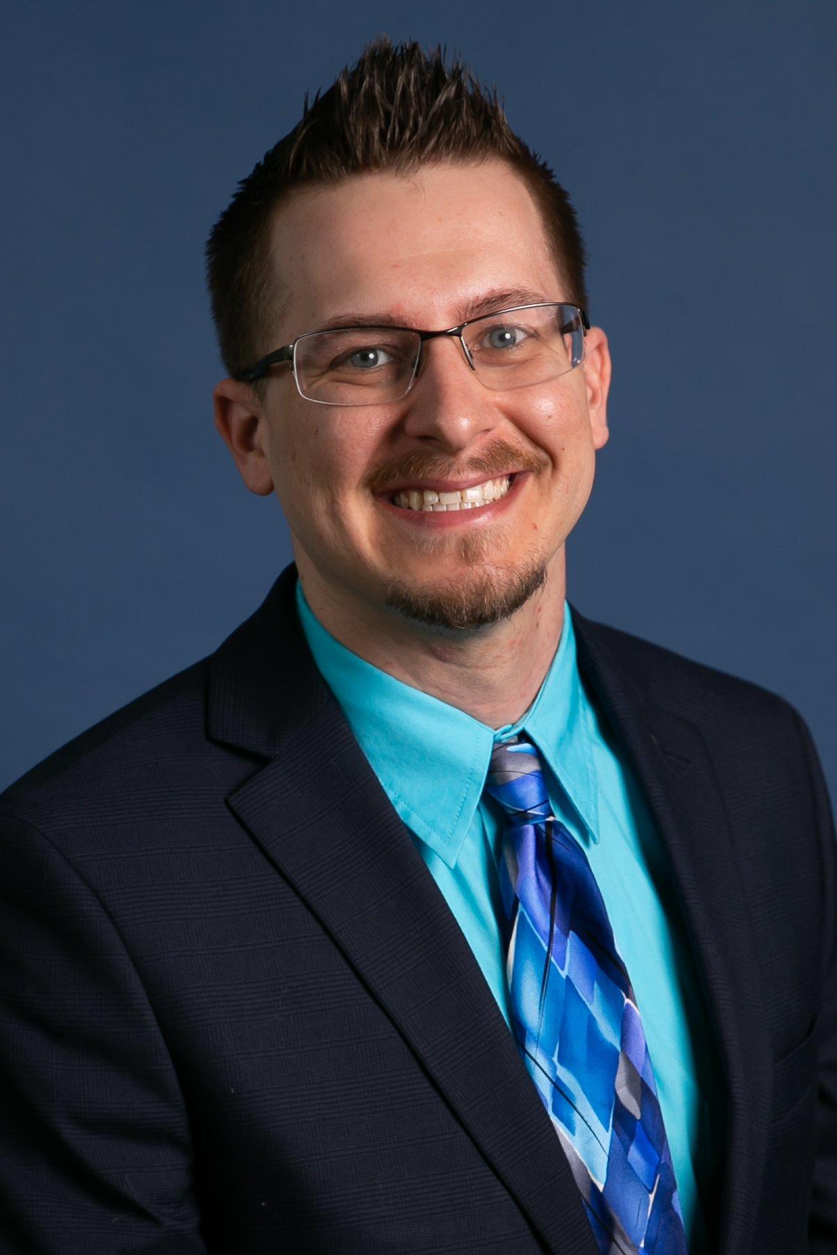 a man wearing glasses and a suit