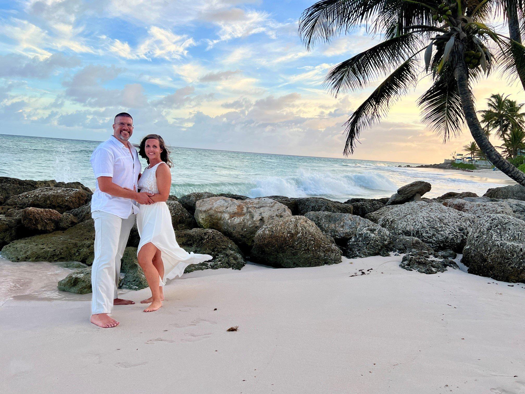 a man and woman posing on a beach