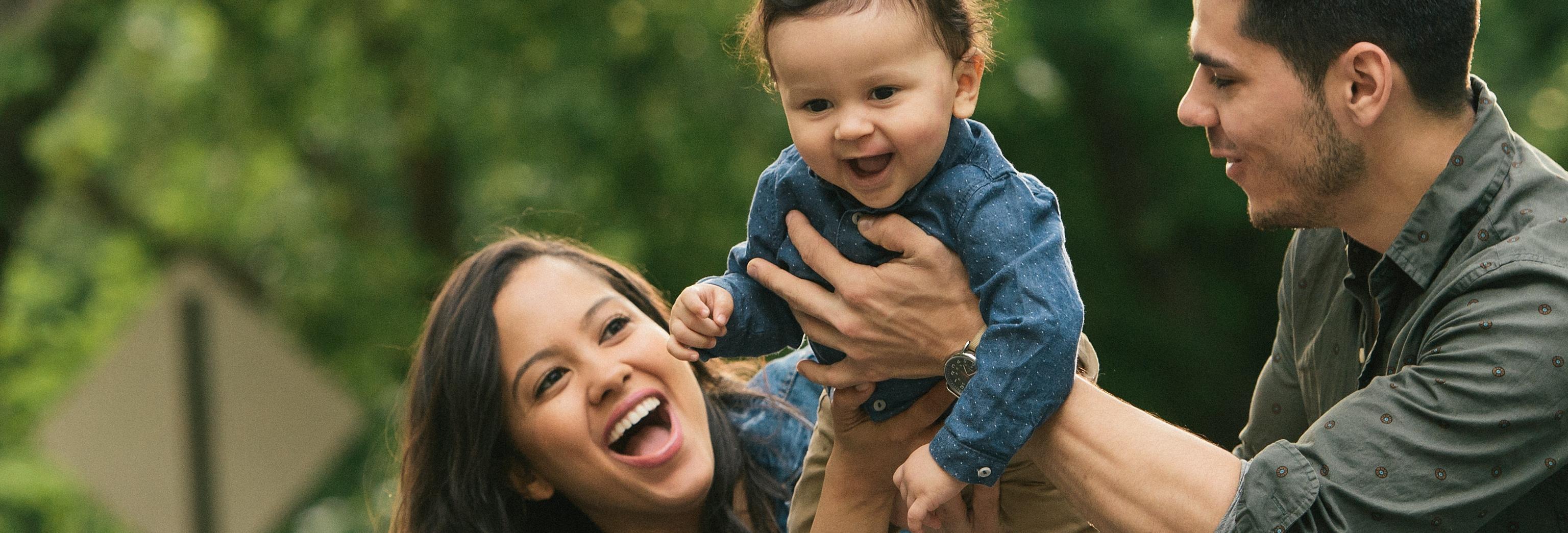 a man and woman holding a baby