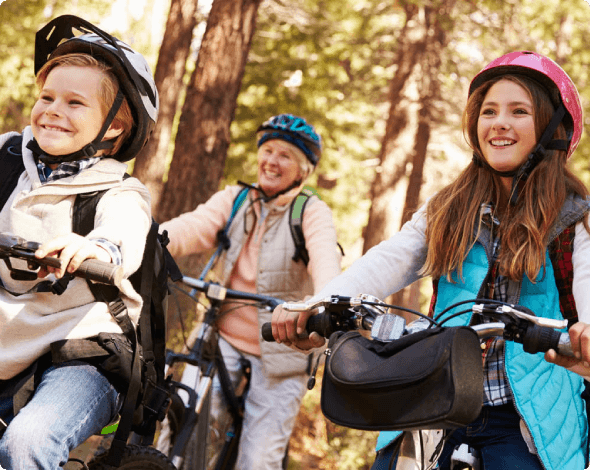 Grandparents and grandkids riding bikes through the forest