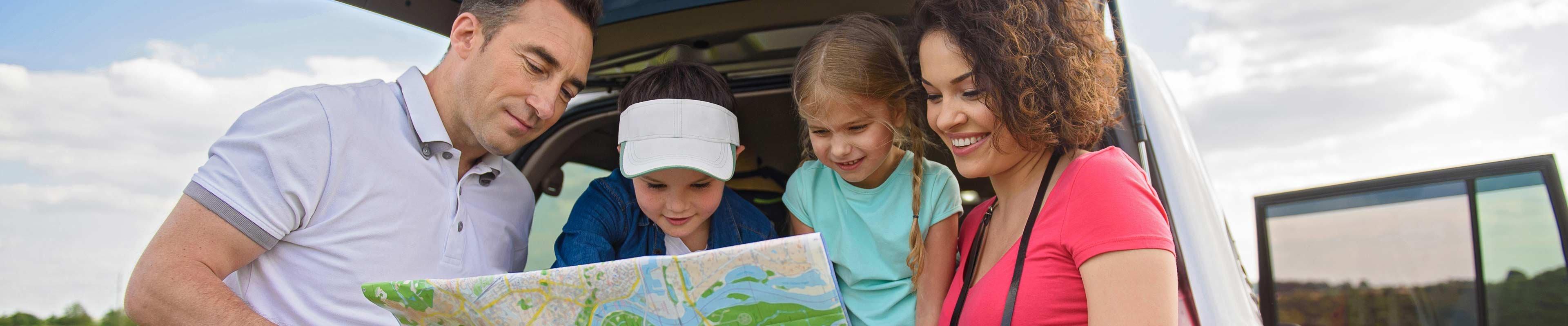 Family on a road trip looking at a map