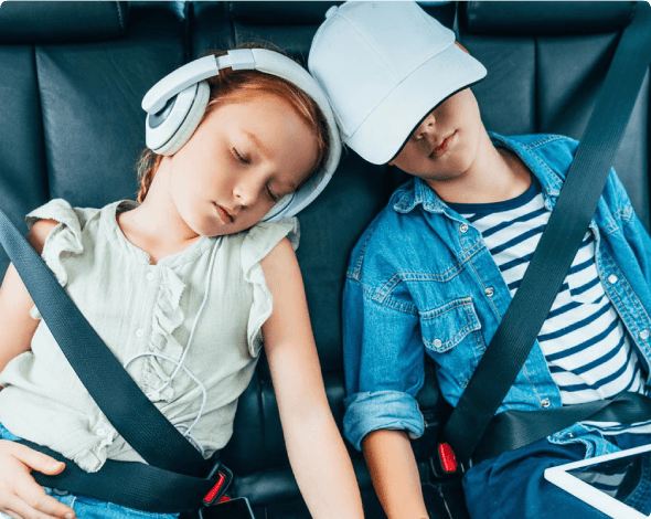 Siblings in the back seat of a car sleeping