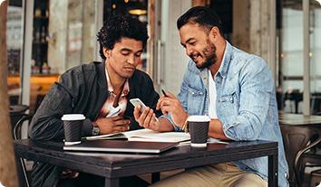 a couple of men looking at a phone