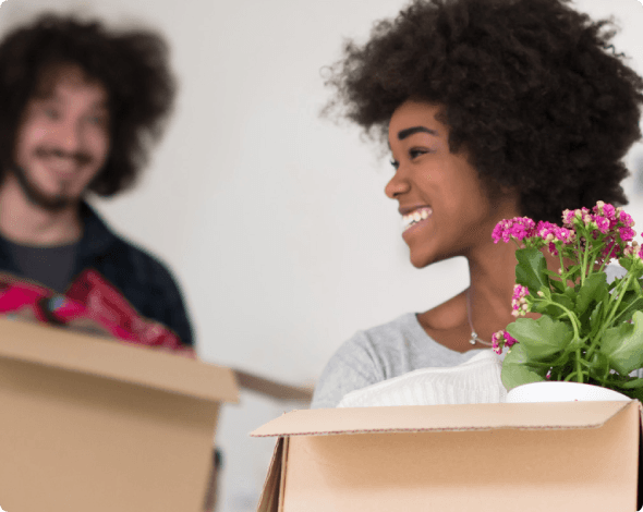 a man and woman carrying moving boxes