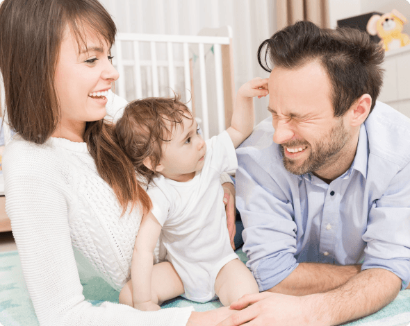 a mother and father playing with their baby