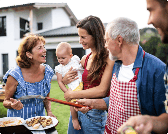 A family cooking cooking outdoors together.