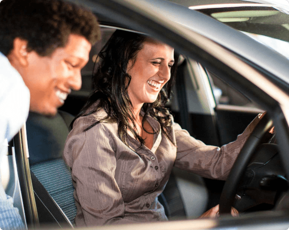 a woman looking at a car with a salesman