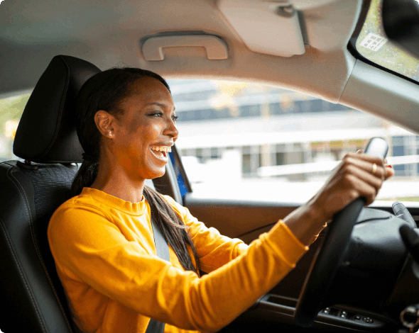 A smiling person going for a drive on a sunny day. 